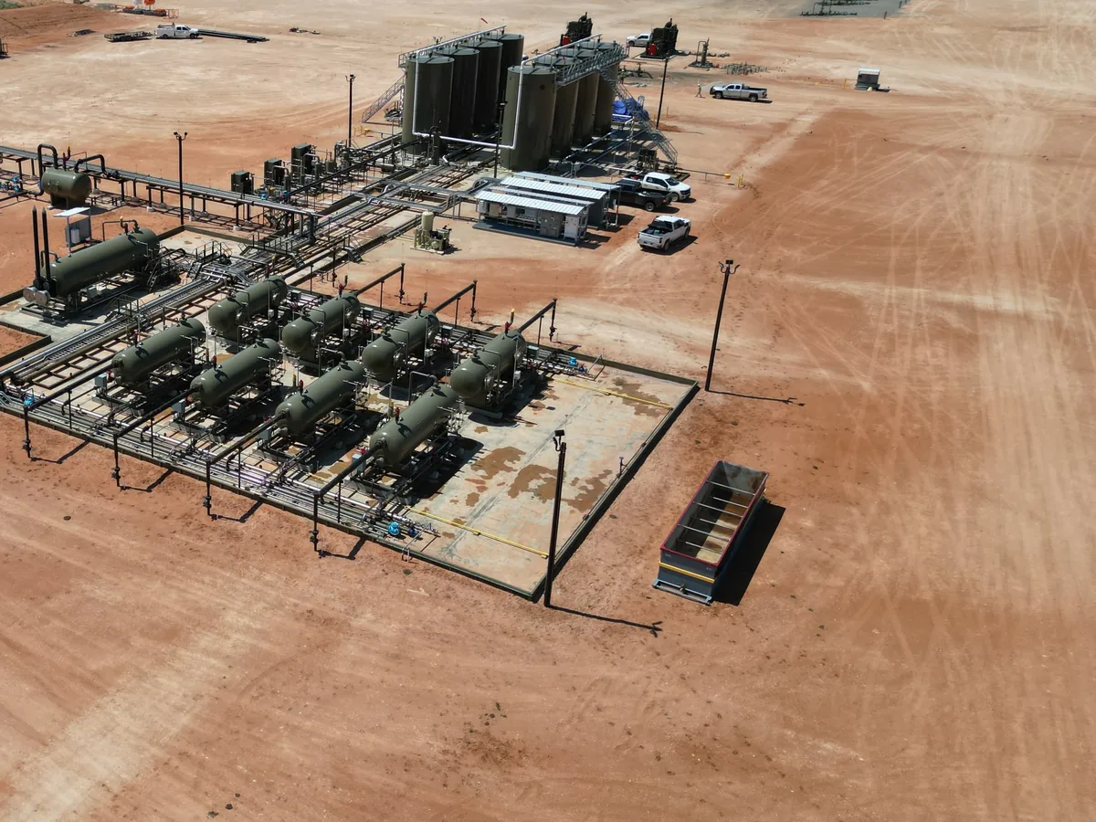 Aerial view of a production facility on a large gravel pad, oilfield services